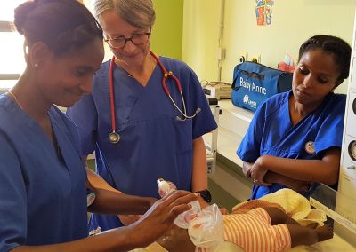 eine deutsche Ärztin erklärt zwei eritreischen Mitarbeiterinnen an einer Puppe die Beatmung